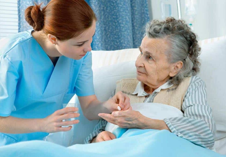 a nurse giving medicine to a senior woman