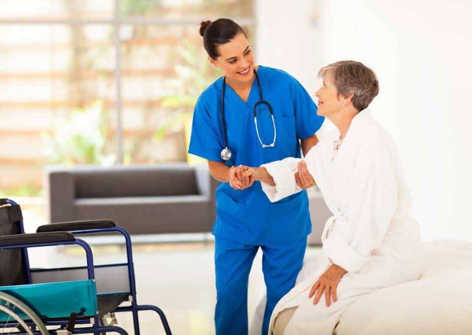 a nurse helping a senior woman to stand up
