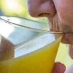 elderly drinking a glass of orange juice
