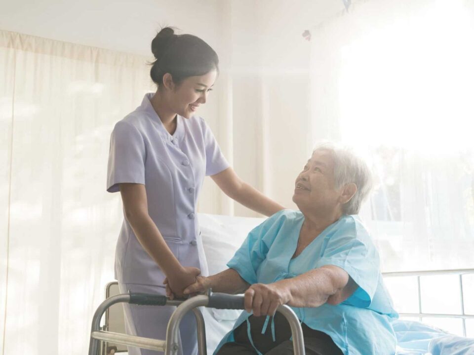 a caregiver shaking hands with a senior woman
