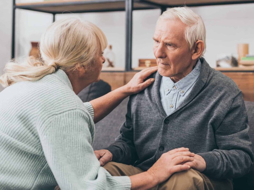 a female caregiver talking to an elderly man