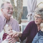 elderly couple holding grandchildren
