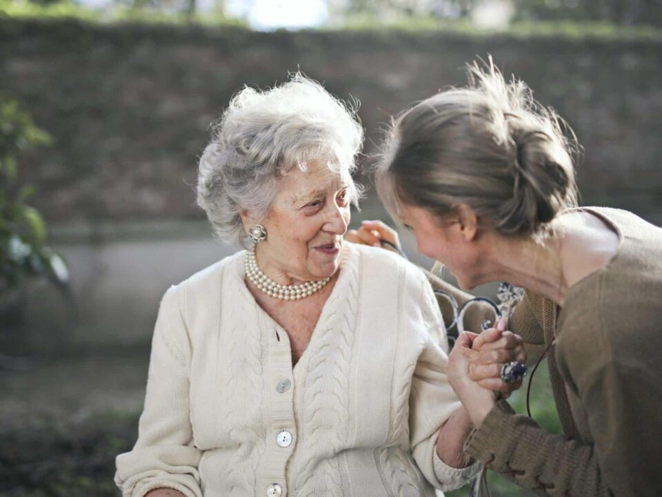 a female caregiver smiling with a senior woman