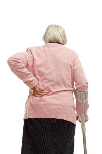 an elderly woman touching her back
