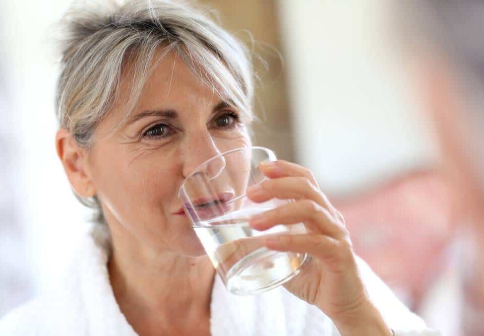 an elderly woman drinking water